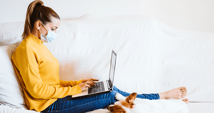A lady working on laptop with mask on face